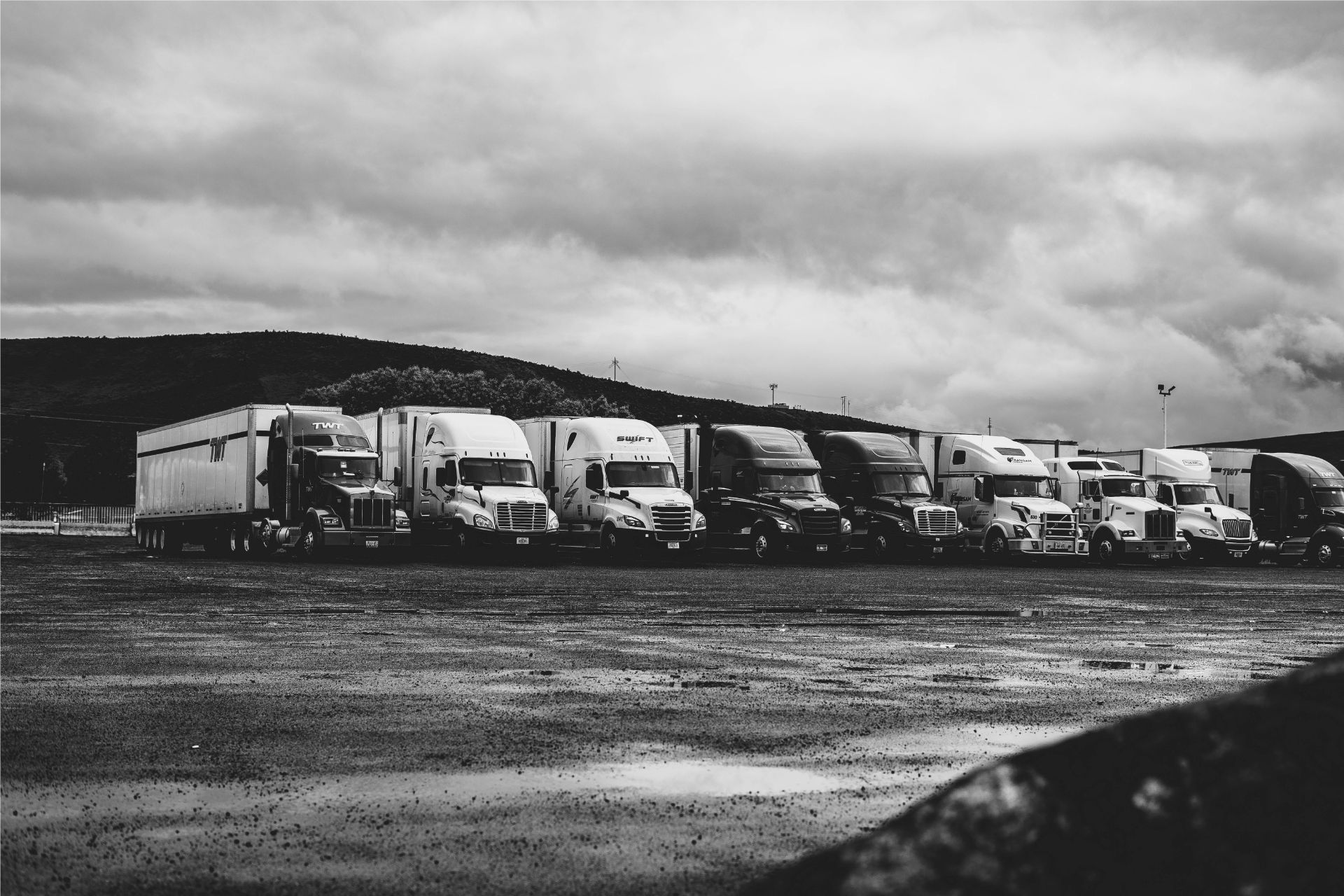 Black and white photo of semi-trucks lined up side to side